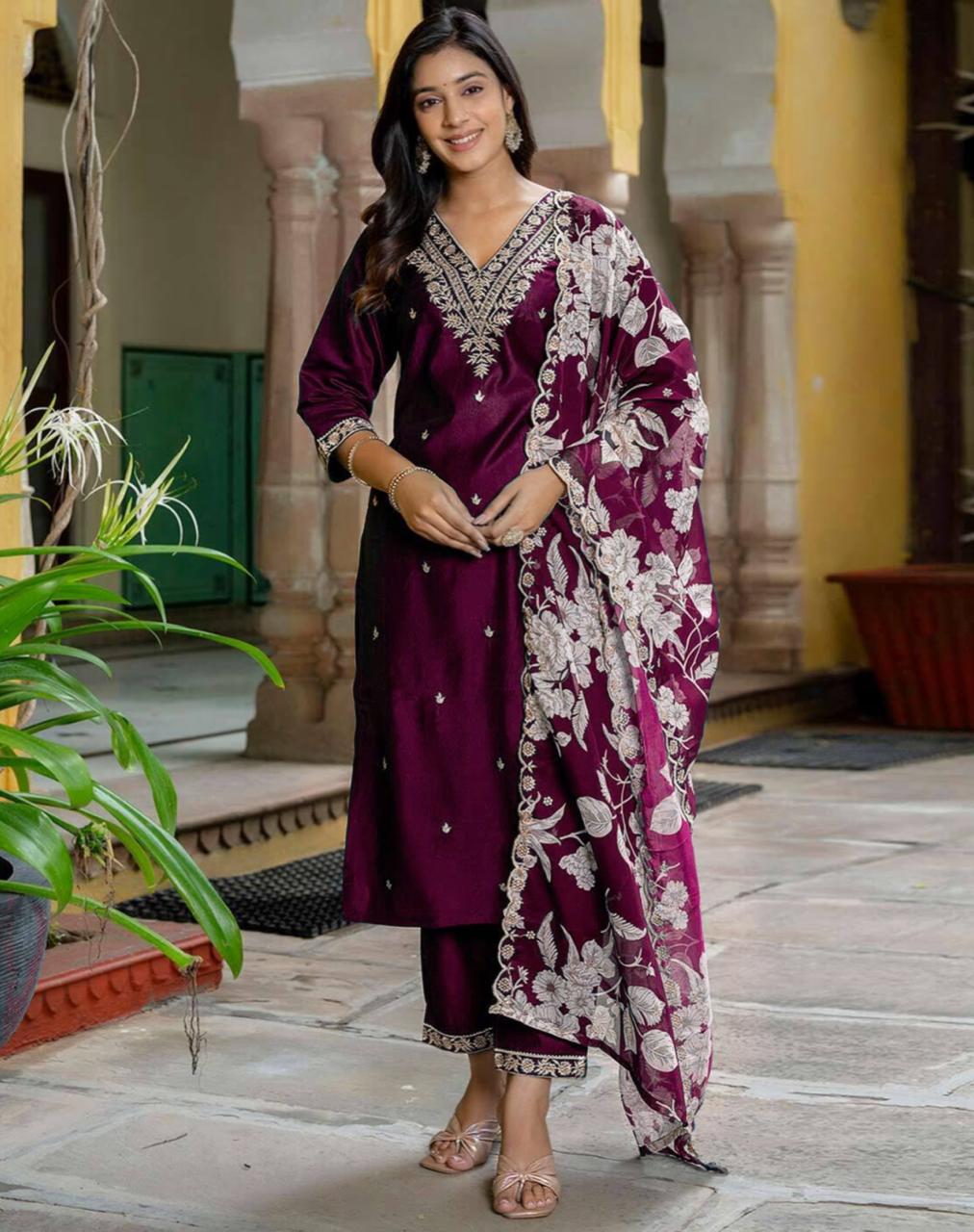 Woman in full-length shot wearing a maroon rayon embroidery kurta set with a floral digital print organza dupatta, posing in an outdoor setting.