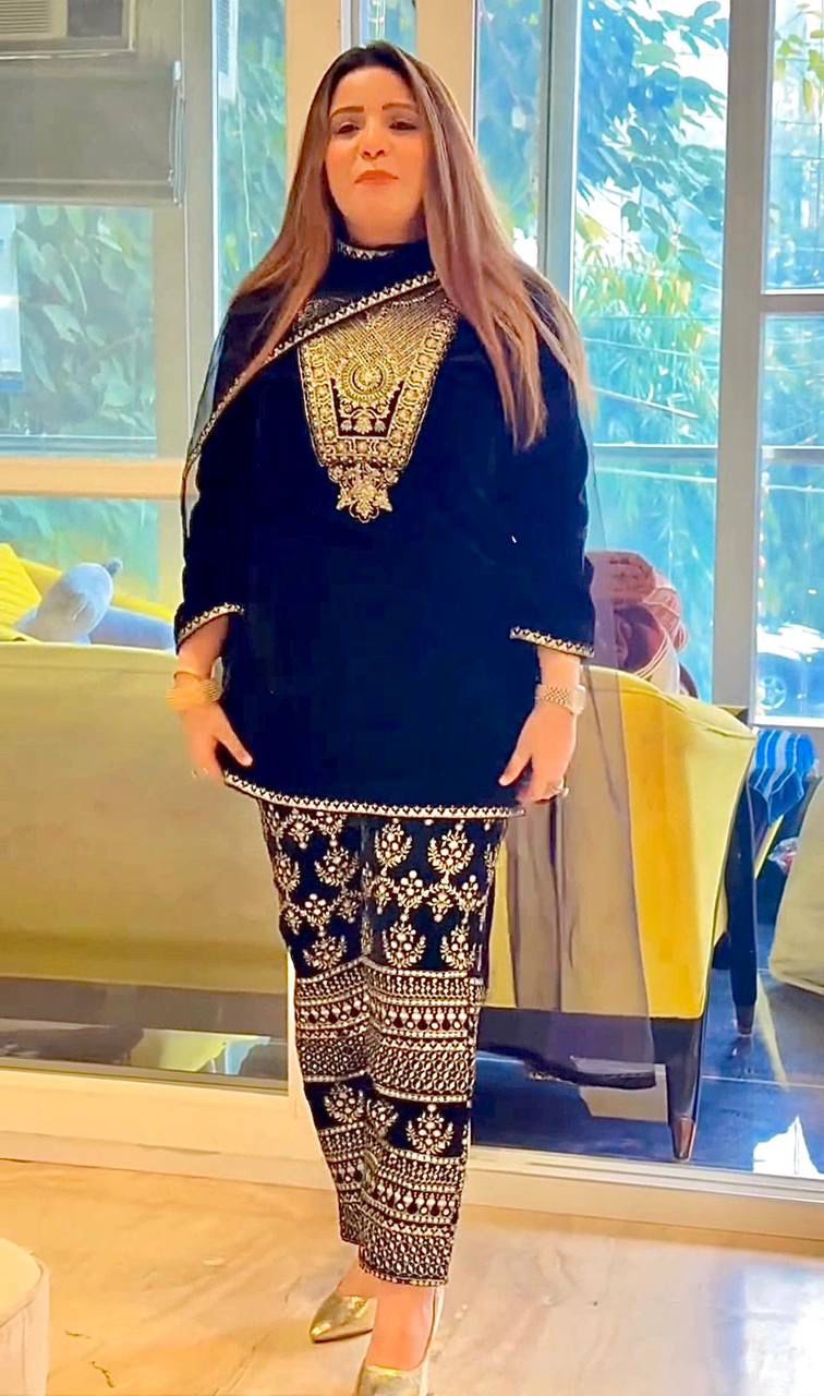 Elegant woman posing in a black heavy viscose velvet kurta plazzo suit with intricate gold embroidery and sequence work, showcasing a fashionable ethnic look.