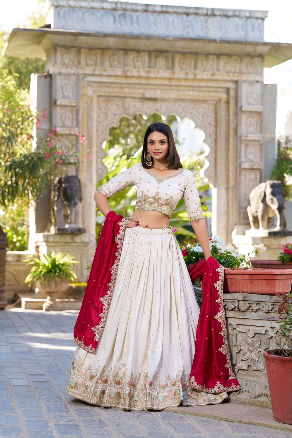 Model wearing traditional cream Vichitra Silk lehenga choli with red dupatta and intricate embroidery.
