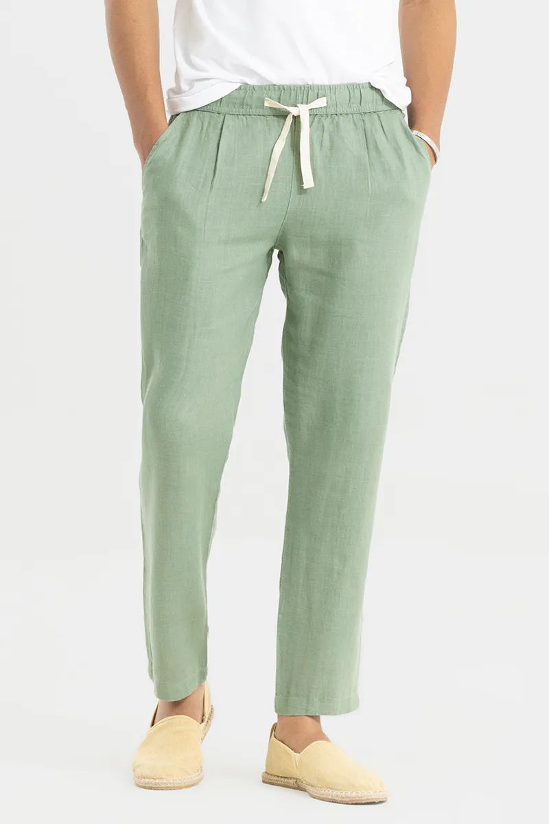Man standing frontally wearing pista green cotton linen pants with a comfortable drawstring waist, paired with espadrilles.
