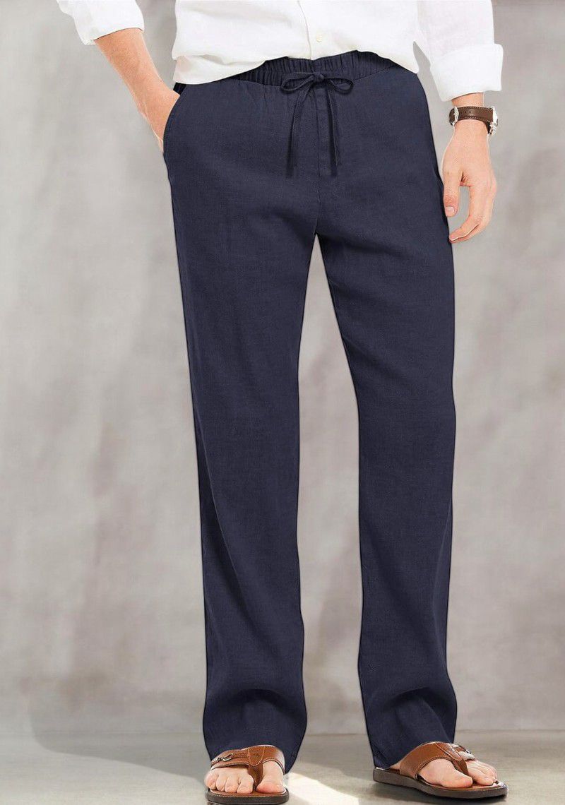 Man standing, hands in pockets, wearing dark navy blue cotton linen pants with a visible drawstring, casual and refined.