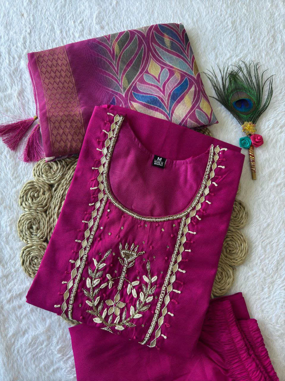 Close-up of intricate handcrafted embroidery on the pink silk kurti neckline