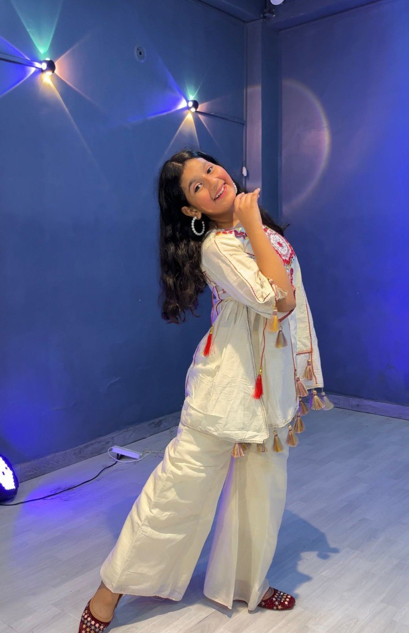 Girl posing dynamically in trendy khadi cotton plazzo set, showcasing side profile and outfit details.