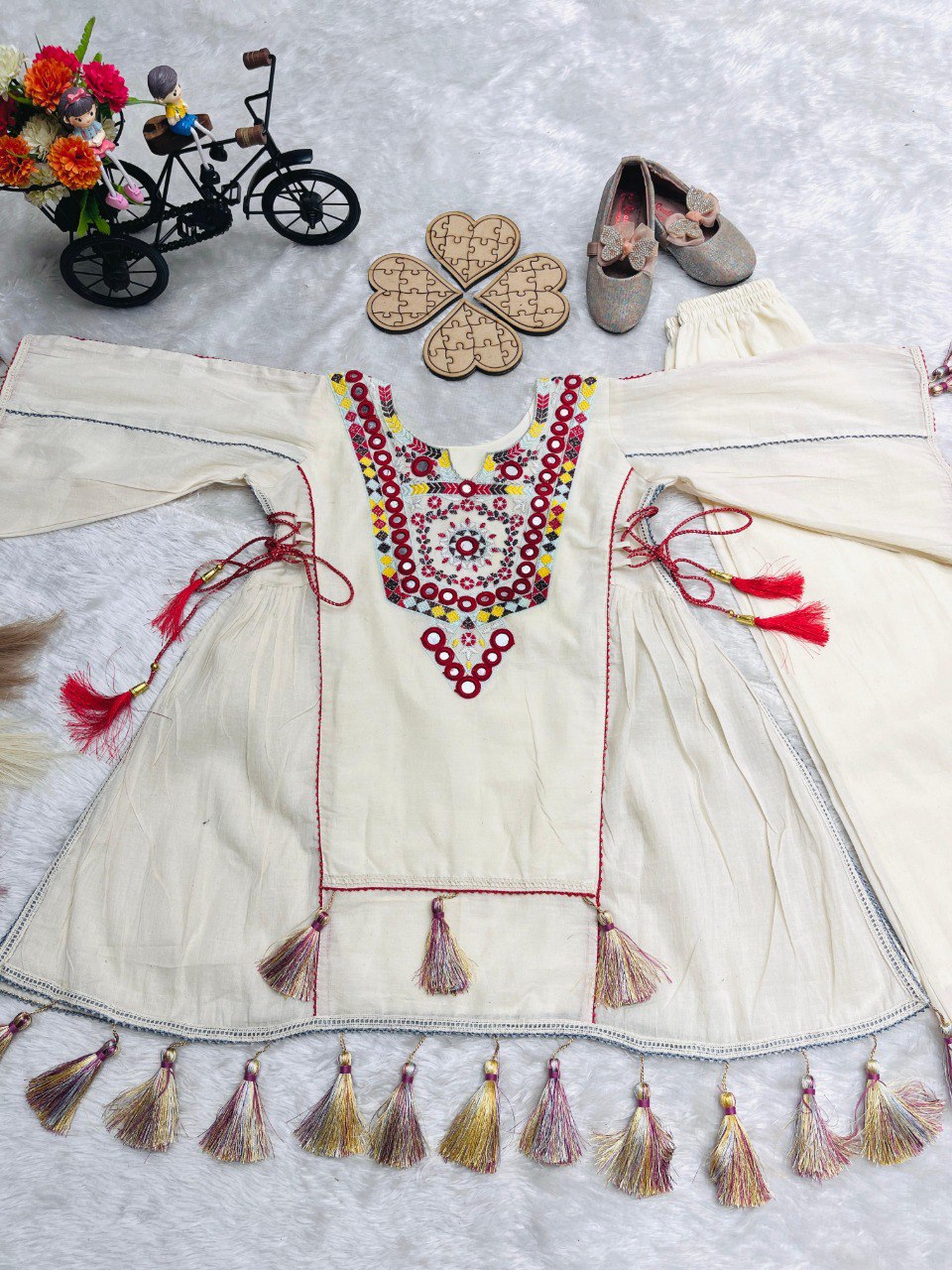 Flat lay of the complete white khadi cotton plazzo set with detailed mirror work on the top's neckline and chest.