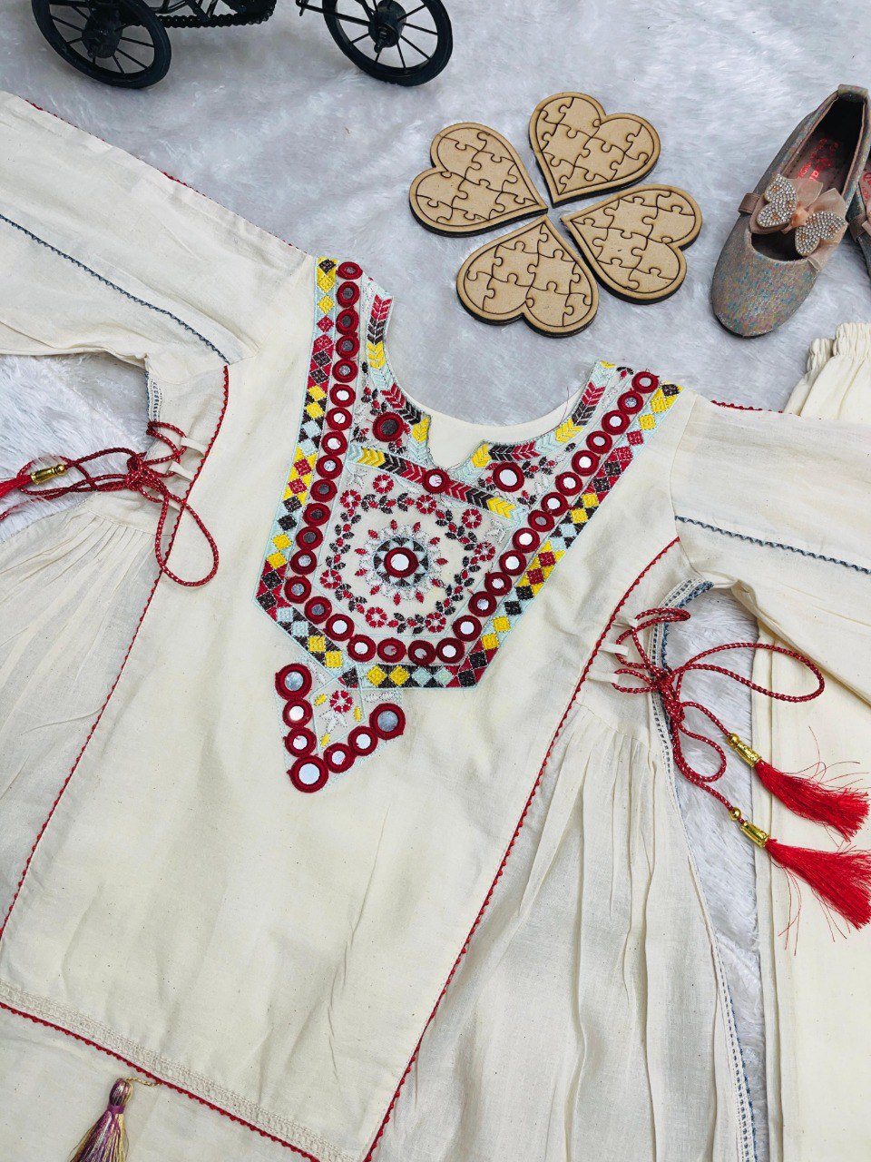 Close-up flat lay of the khadi cotton top's neckline, showcasing the detailed red, yellow, and black embroidery with real mirrors and sequence work.