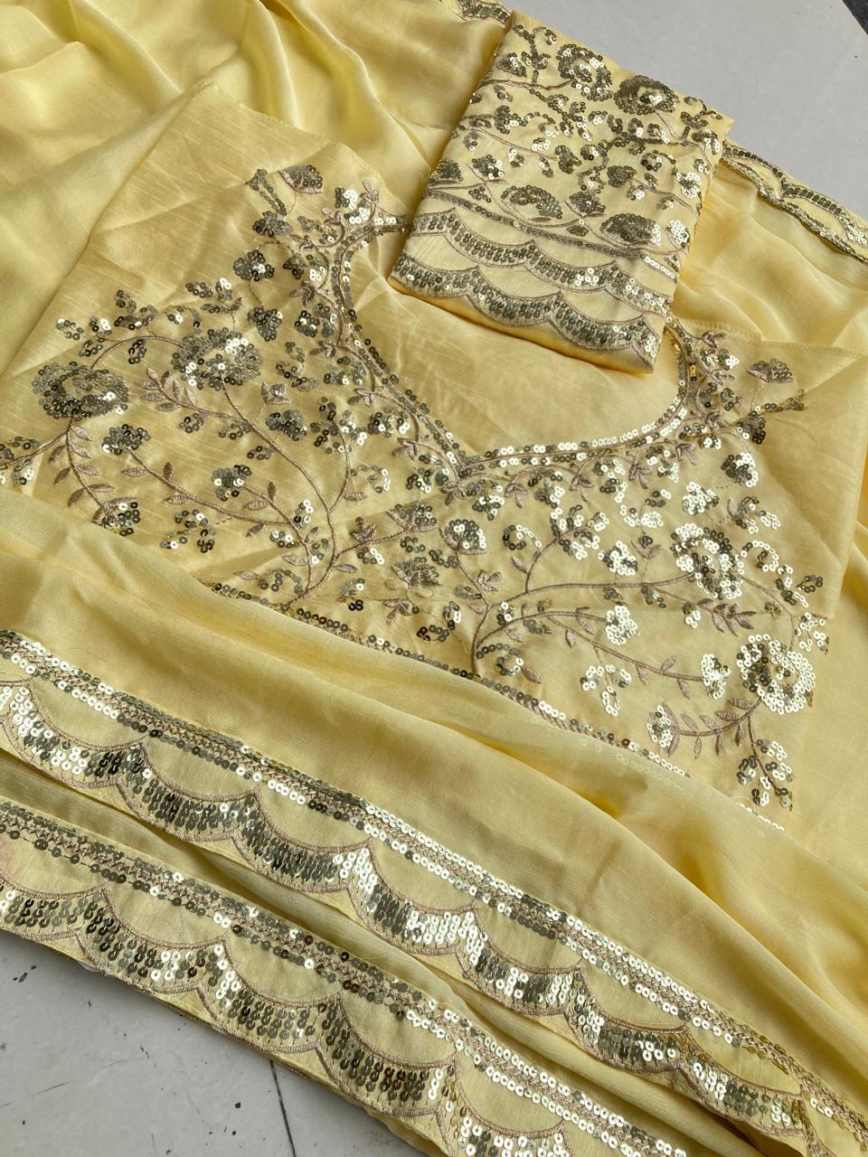 Overhead view of the light yellow Moss Chiffon saree spread out, displaying the intricate sequin lace border and the unstitched embroidered Mono Banglory silk blouse fabric.
