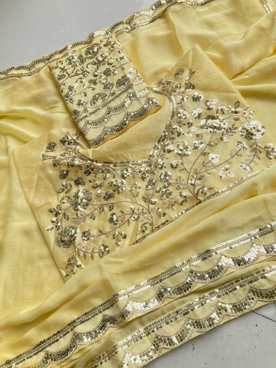 Another comprehensive overhead view of the light yellow saree and its embroidered blouse, with a focus on the texture and sparkling details.