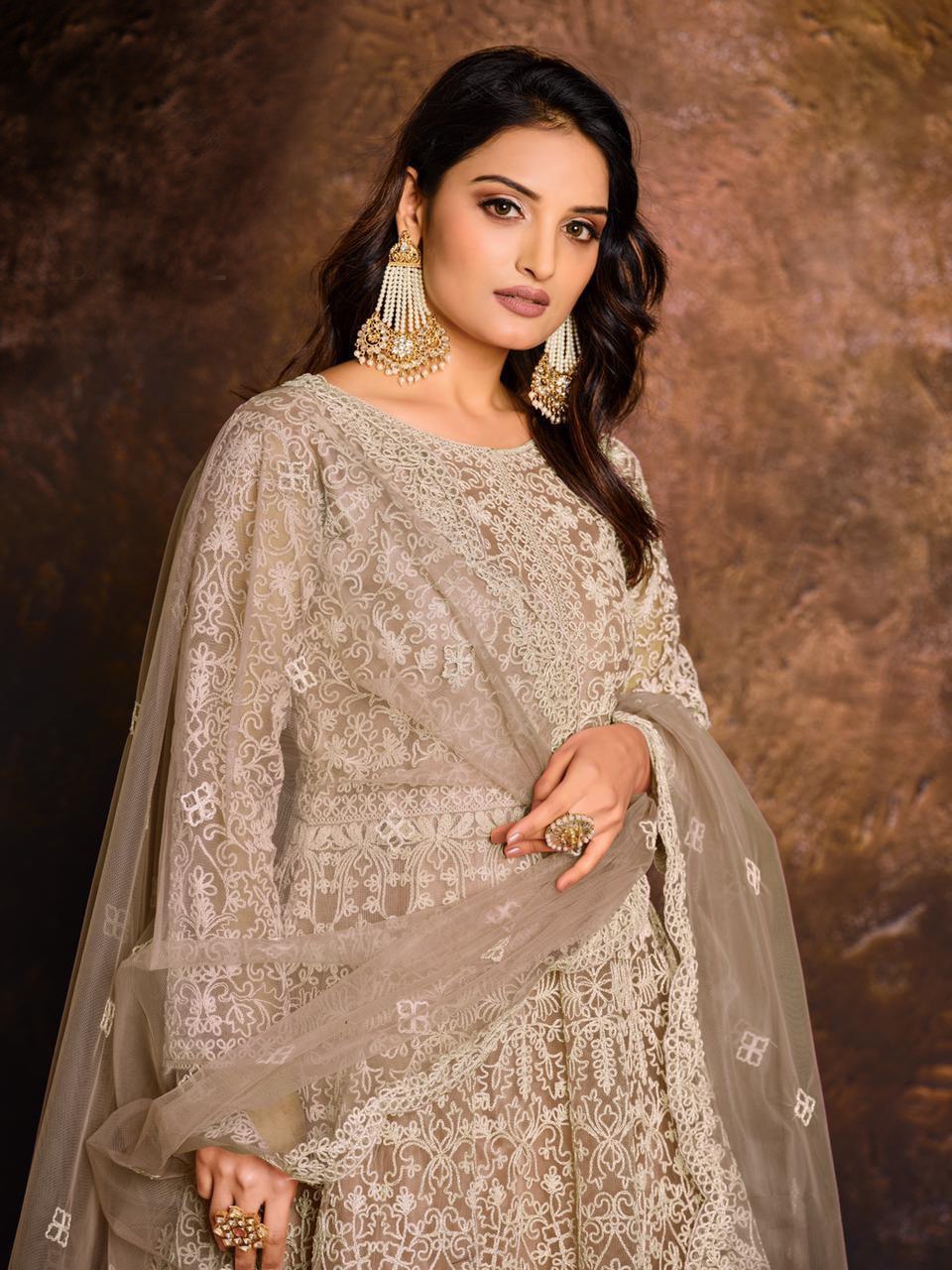 TRENDBUY model showcasing a heavy Rangoli sequence embroidered semi-stitched Anarkali gown in beige-gold, close-up.