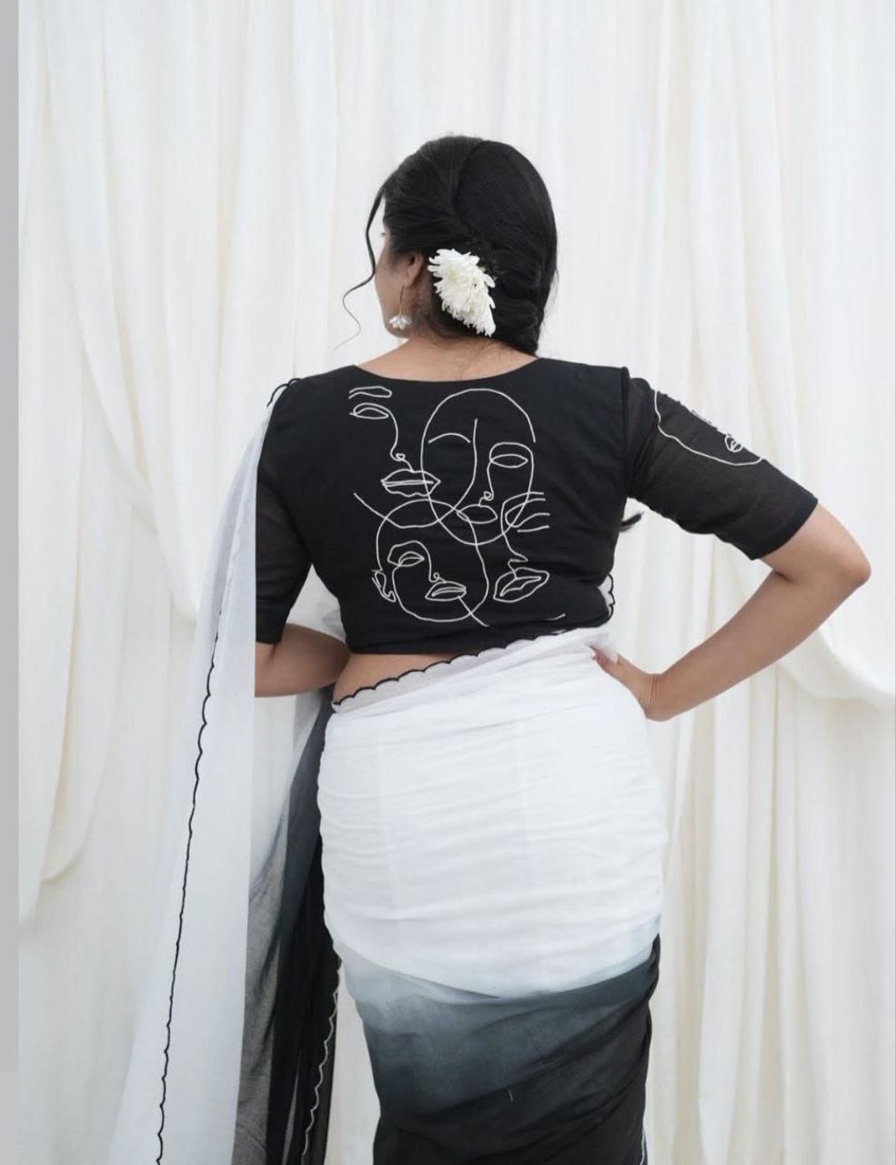 Back view of model in black and white ombre saree, highlighting the unique white abstract face line art on the black blouse.
