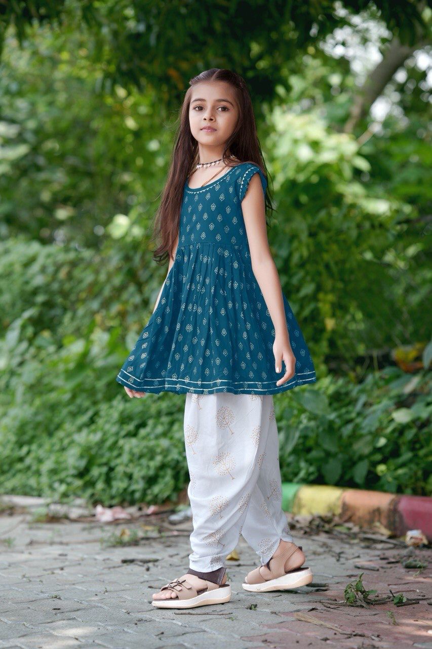 Young girl wearing the blue rayon foil print kurti and white dhoti pants set