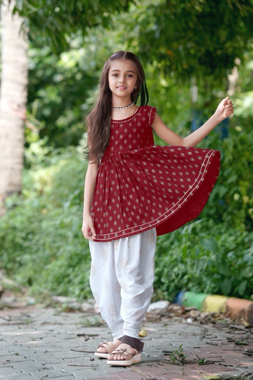 Girl twirling in the maroon foil print kurti and dhoti patiala set
