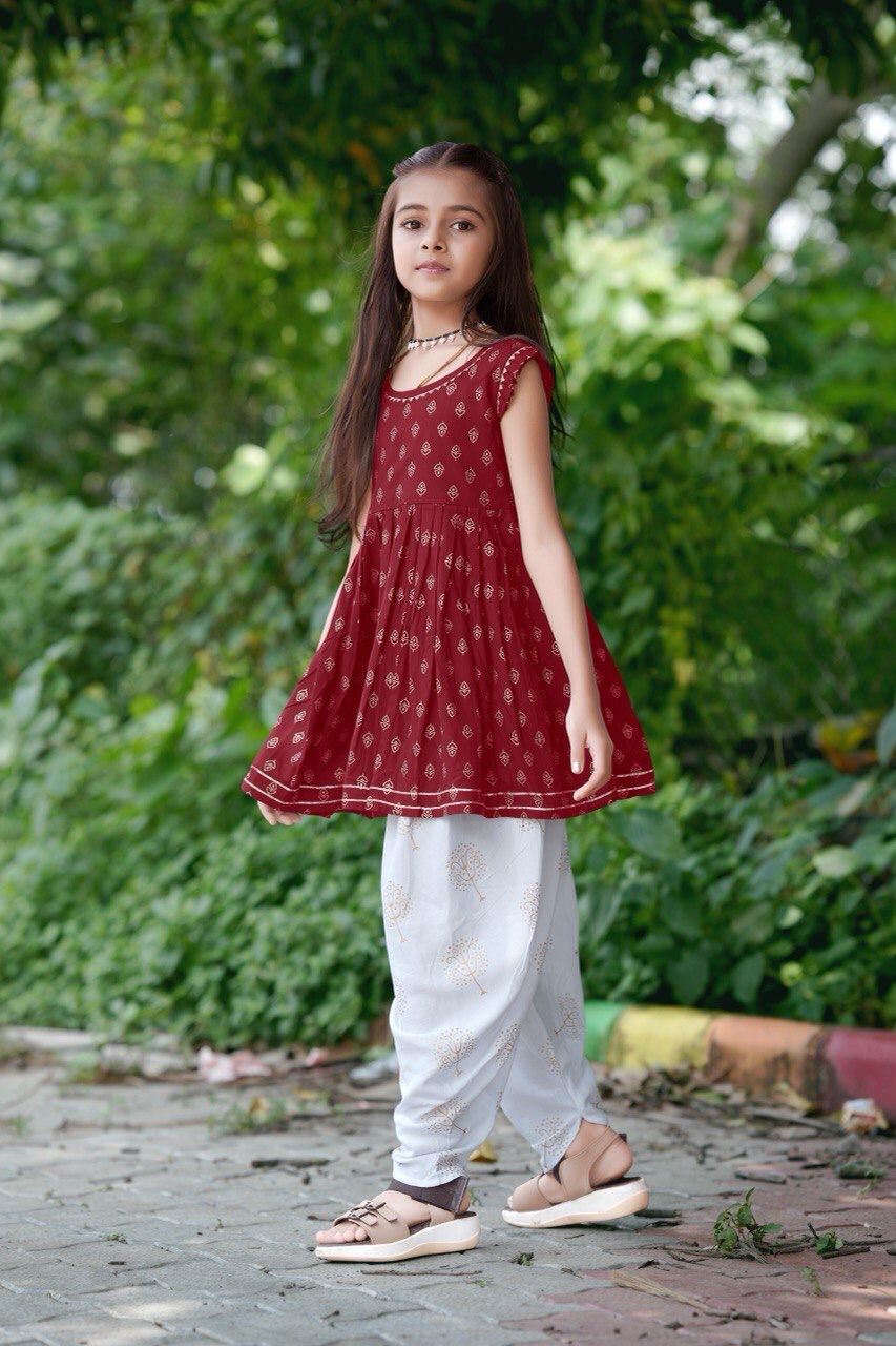 Girl twirling in the maroon foil print kurti and dhoti patiala set