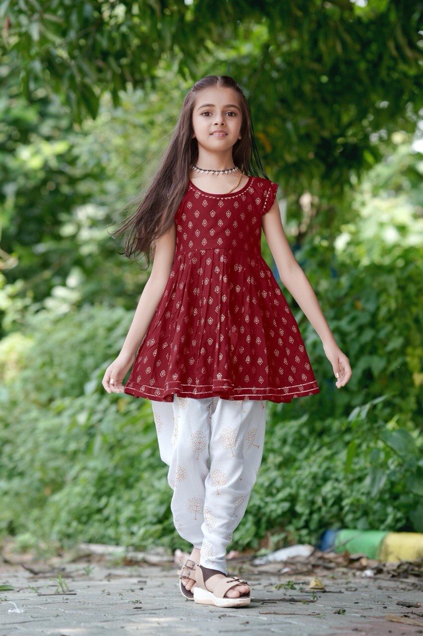 Girl twirling in the maroon foil print kurti and dhoti patiala set