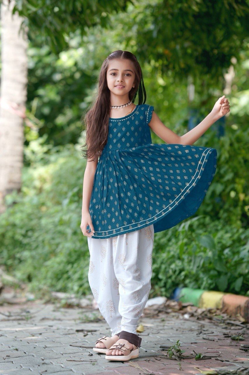 Girl twirling in the teal blue foil print kurti and dhoti patiala set