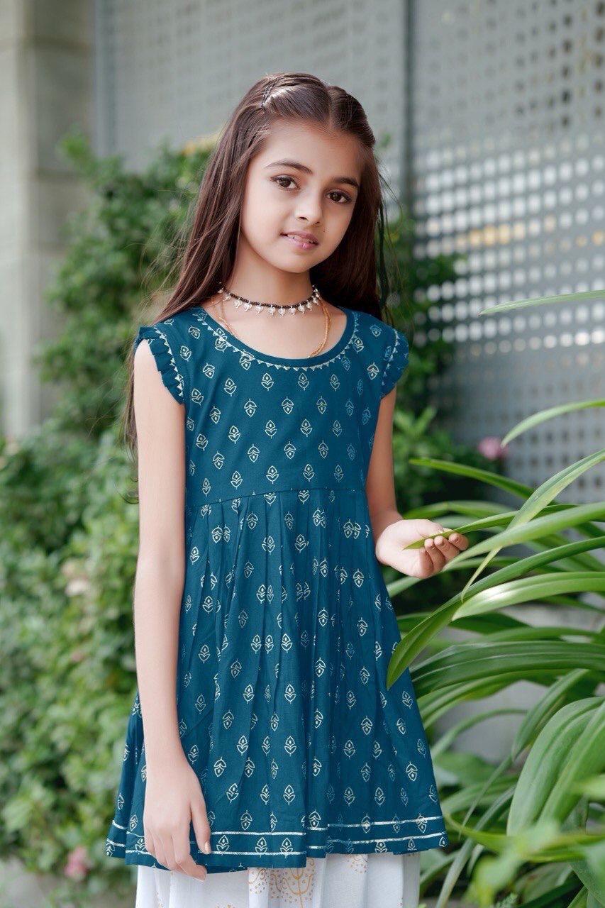 Girl twirling in the teal blue foil print kurti and dhoti patiala set
