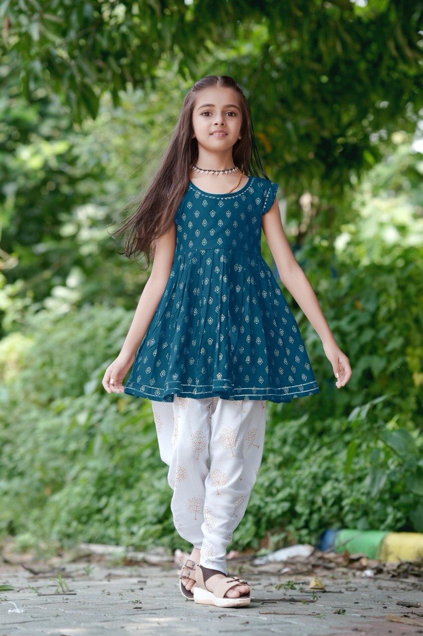 Girl twirling in the teal blue foil print kurti and dhoti patiala set