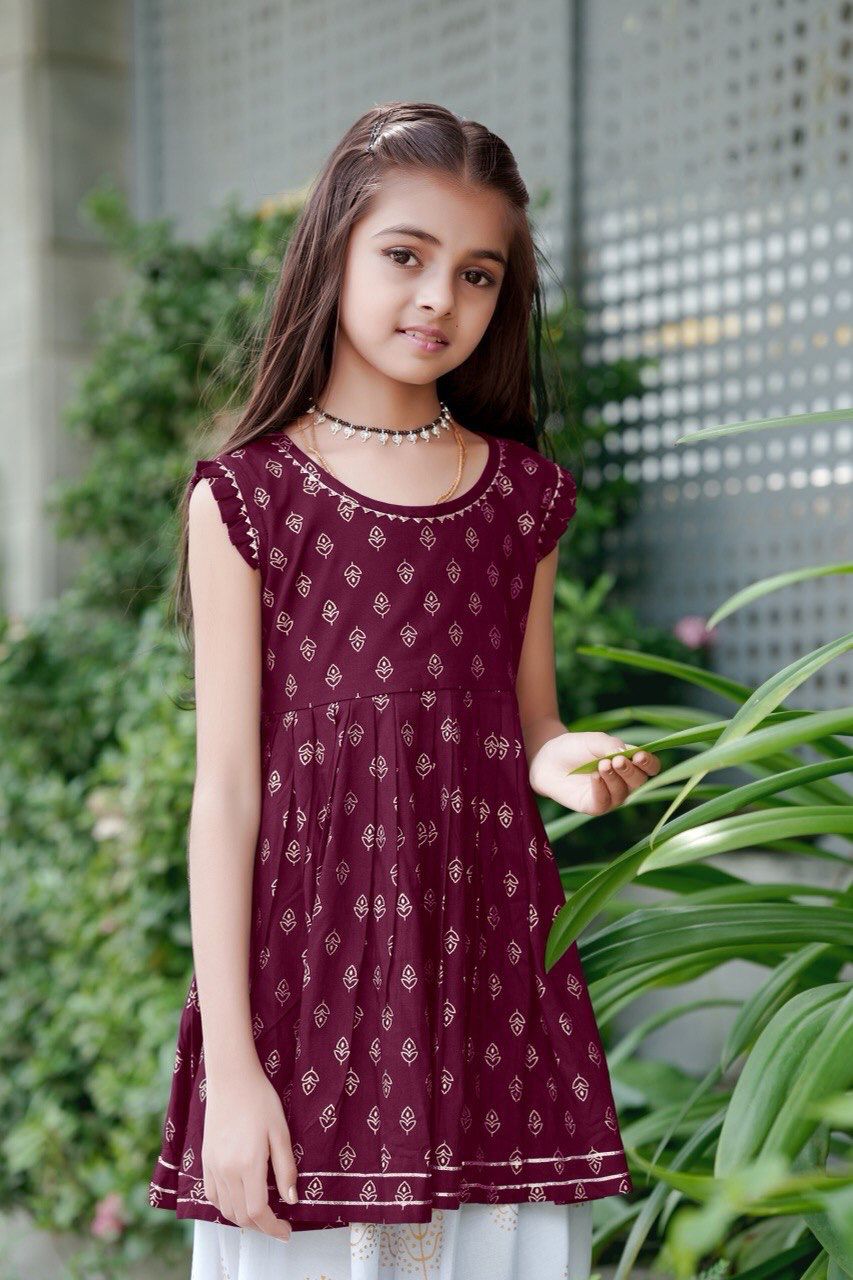 Girl twirling in the maroon foil print kurti and dhoti patiala set