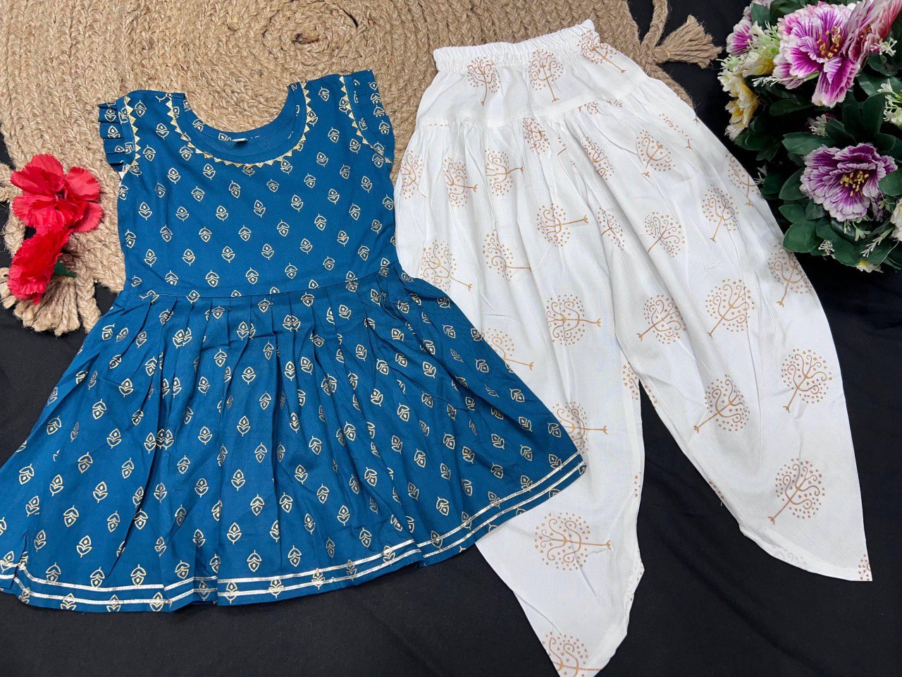 Flat lay of the kids teal blue kurti and white printed dhoti set