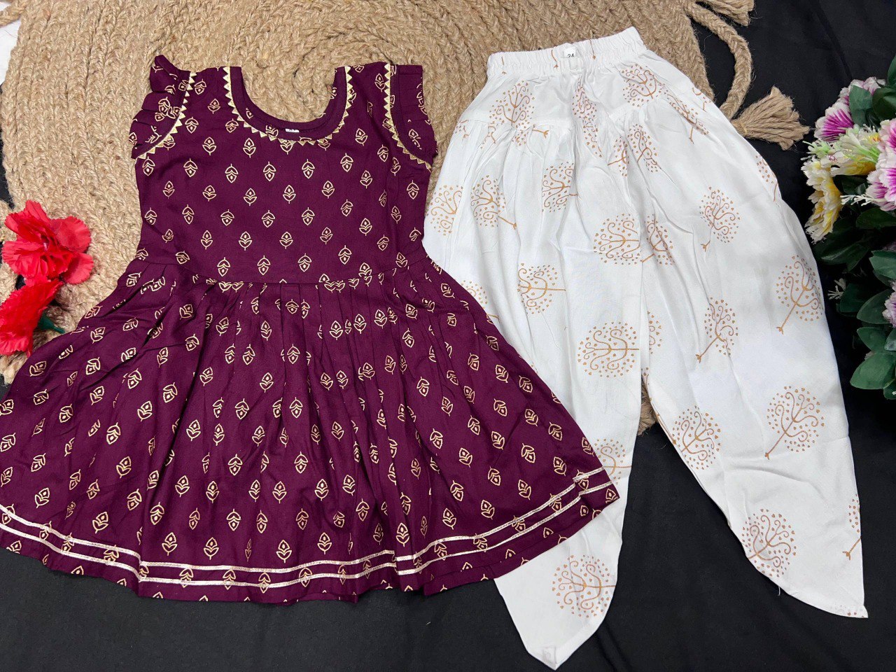 Flat lay of the kids maroon kurti and white printed dhoti set