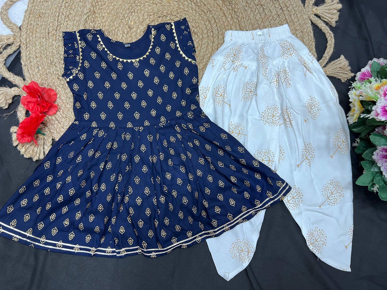 Flat lay of the kids navy blue kurti and white printed dhoti set