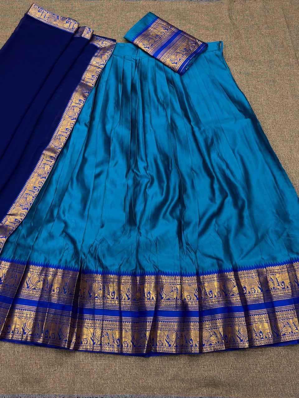 Close-up of the intricate gold and blue Zari weaving on the Kanjivaram silk lehenga border.