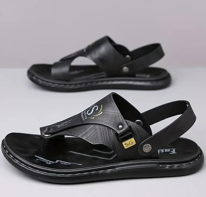 Black sandals with a brand logo on a light gray background