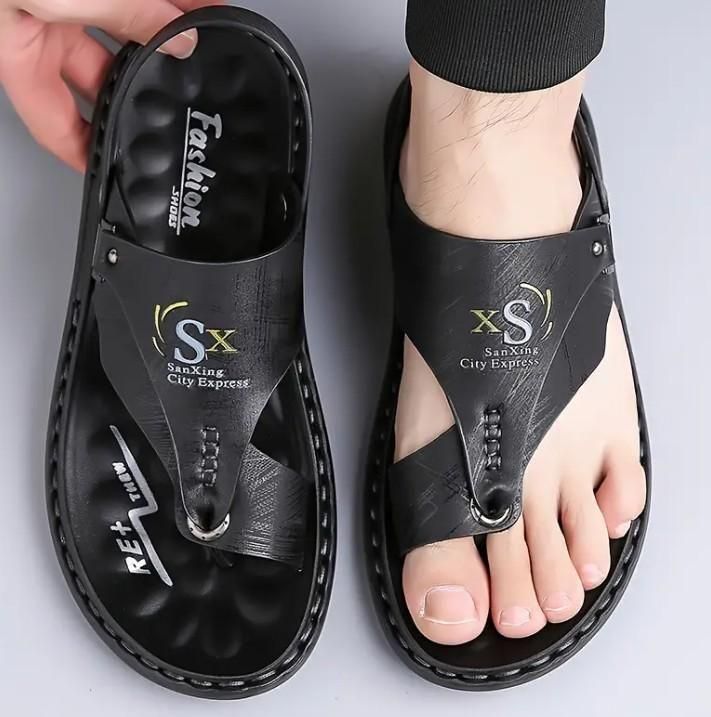 Black sandals with brand logo on a gray background
