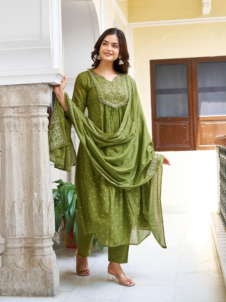 Full shot of a model in an olive green embroidered kurti set, holding the dupatta to her side, presenting a stylish and comfortable look.