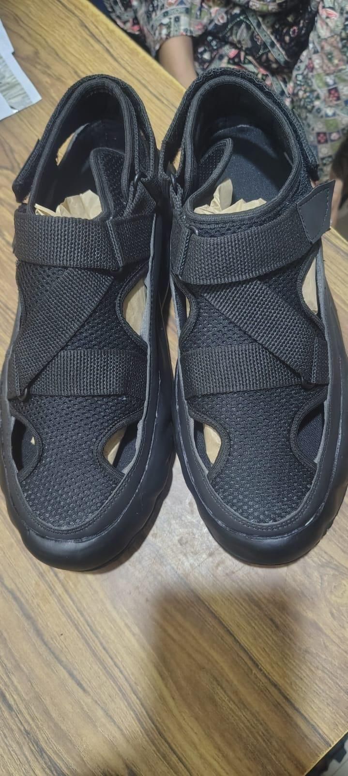 Black sandals on a wooden surface
