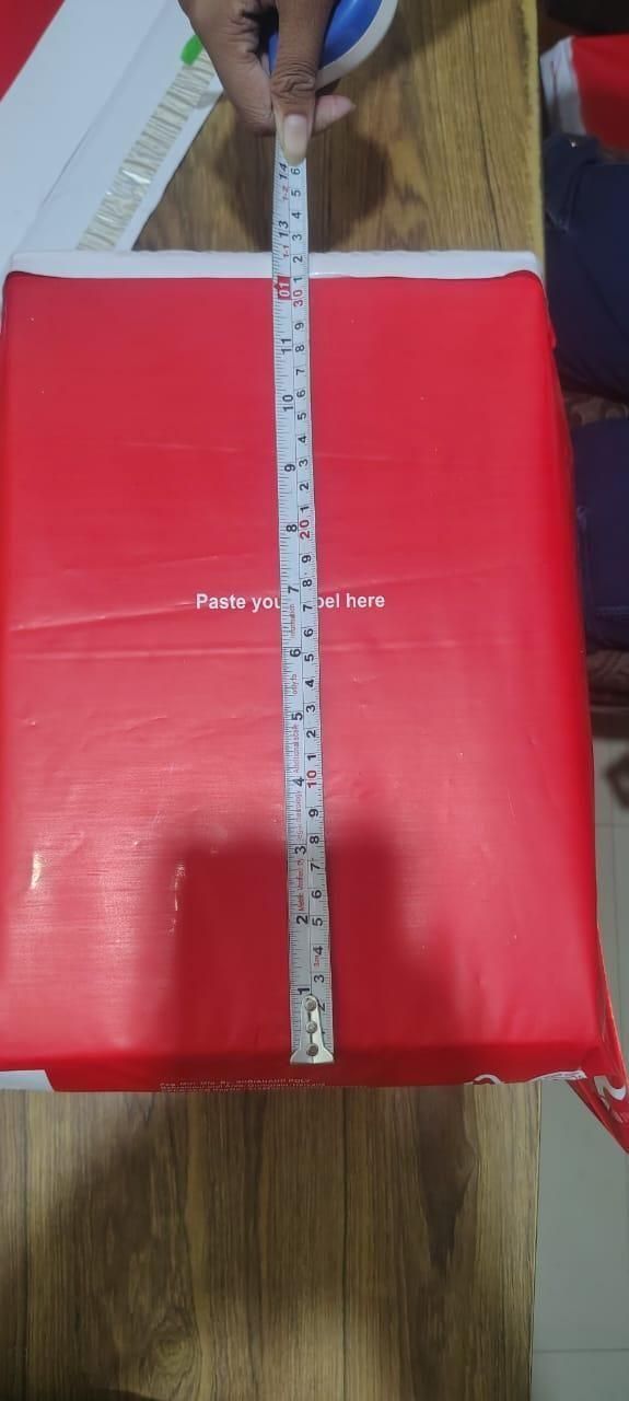 Red package with a ruler on a wooden surface