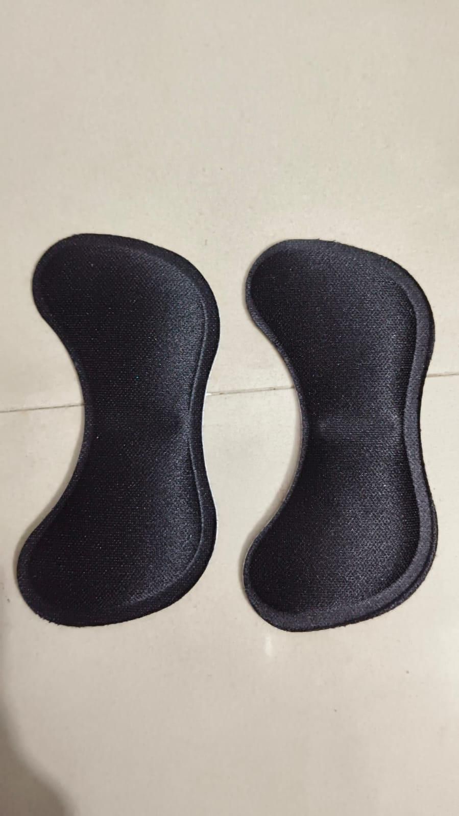 Pair of black silicone gel pads on a light gray surface