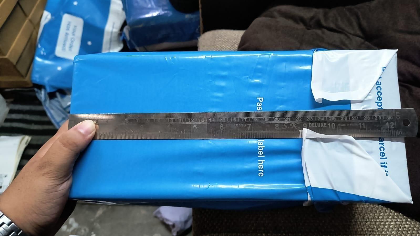 Blue box with a ruler on top, held by a hand