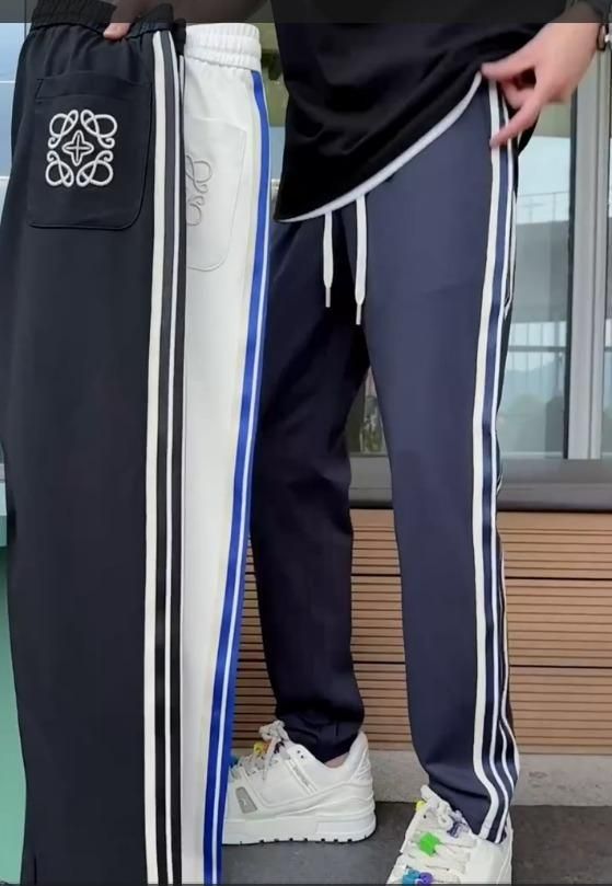 Man wearing navy blue comfortable striped trackpants with white side stripes, highlighting fit and comfort.
