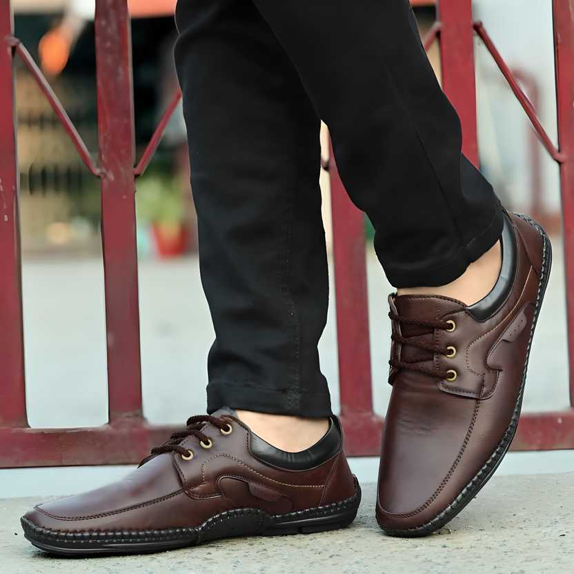 Brown leather shoes worn with black pants against a blurred background