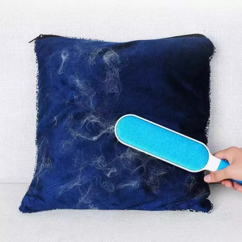 Multi-purpose double-sided pet hair remover tool lifting dog and cat fur from a dark sofa.