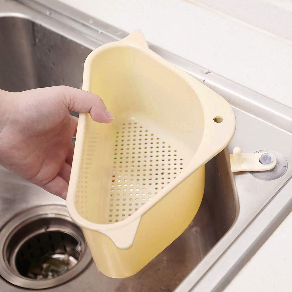 Triangular multi-functional sink drainer shelf holding a sponge and brush.