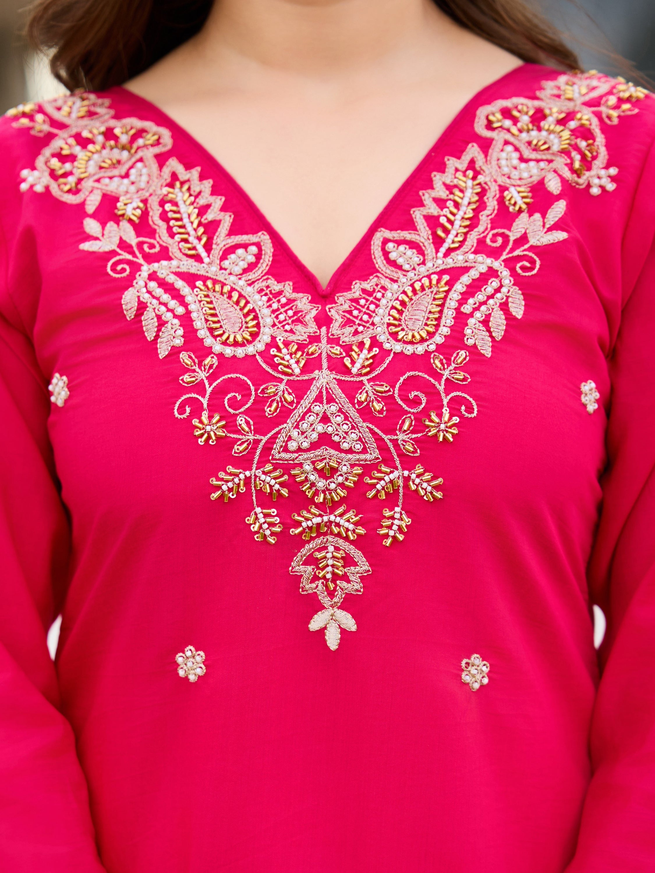 Close-up of V-neck, intricate gold and silver bead embroidery on pink Roman silk kurti.