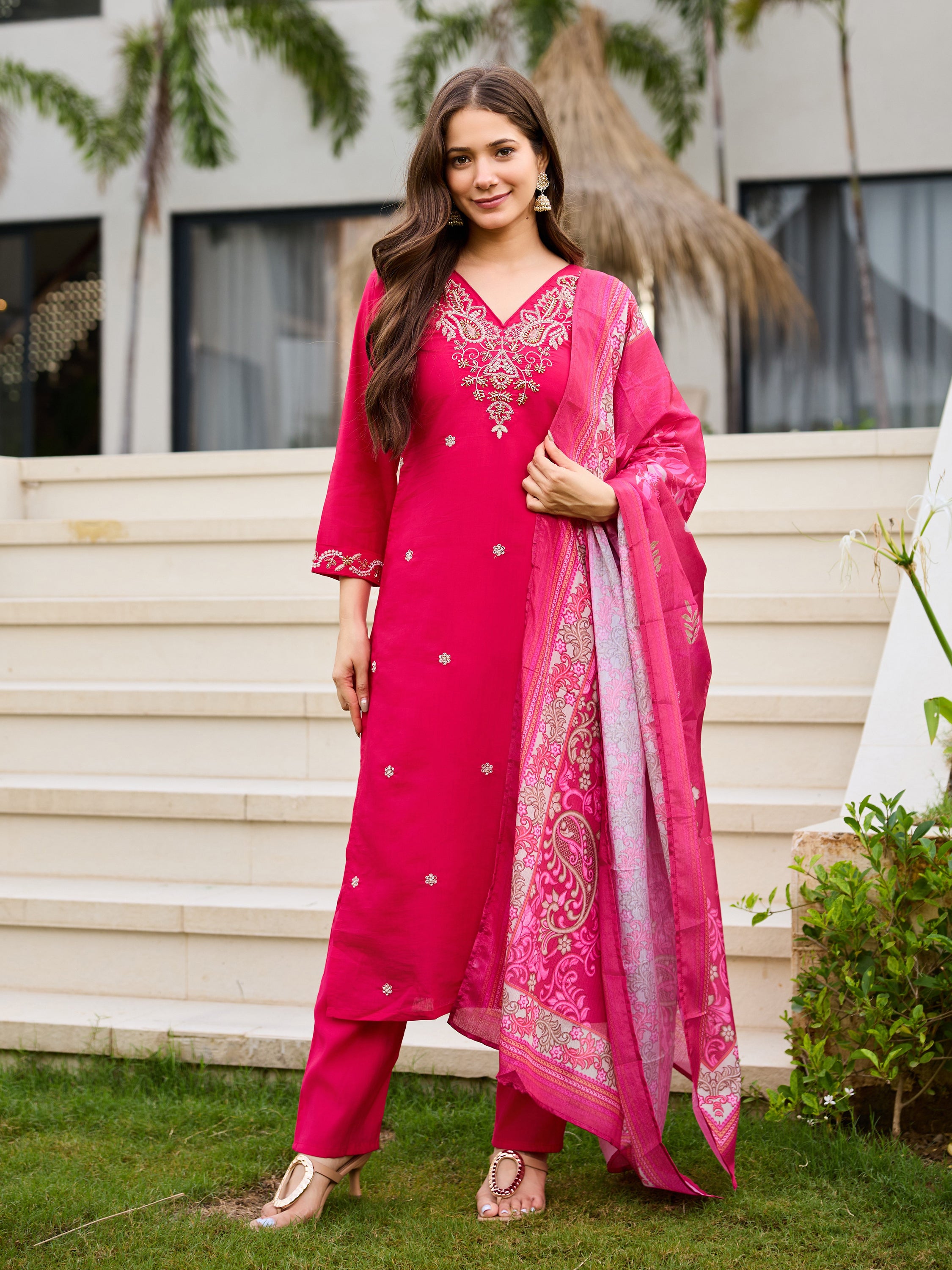 Woman elegantly posing in the pink Roman silk kurti set with the patterned dupatta, looking stylish.