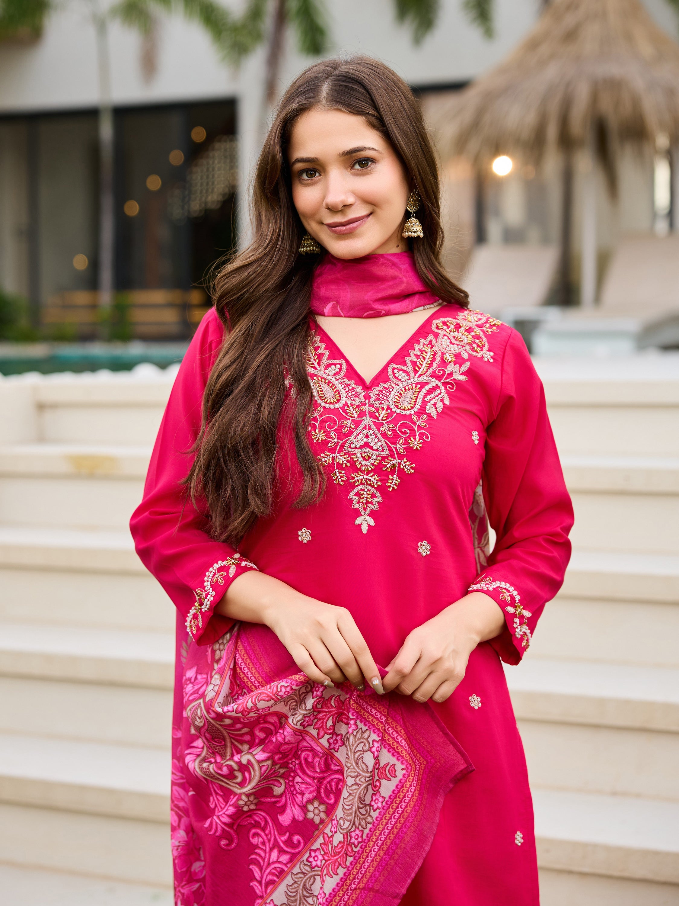 Close-up portrait of a woman's upper body, featuring the V-neck kurti with embroidery and a part of the floral dupatta.