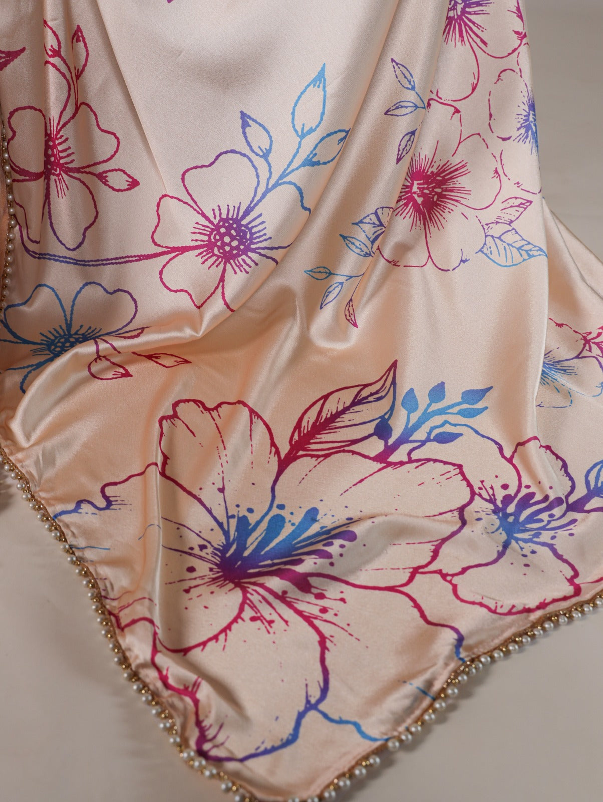 Cream Japan satin silk saree with digital floral print and elegant pearl lace border.