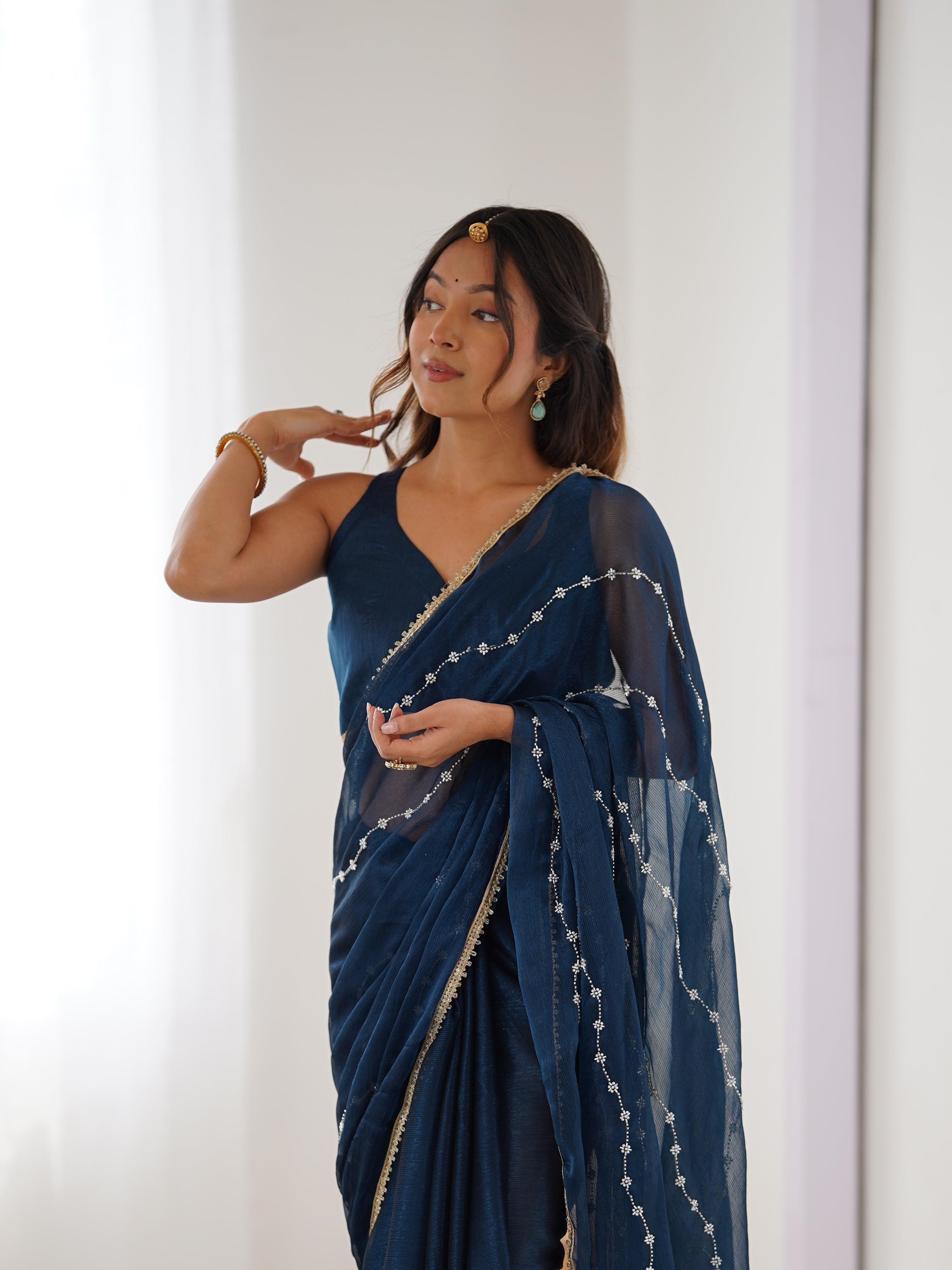 Model in Petrol Blue Sitara Saree, side profile showing graceful drape and bead work.