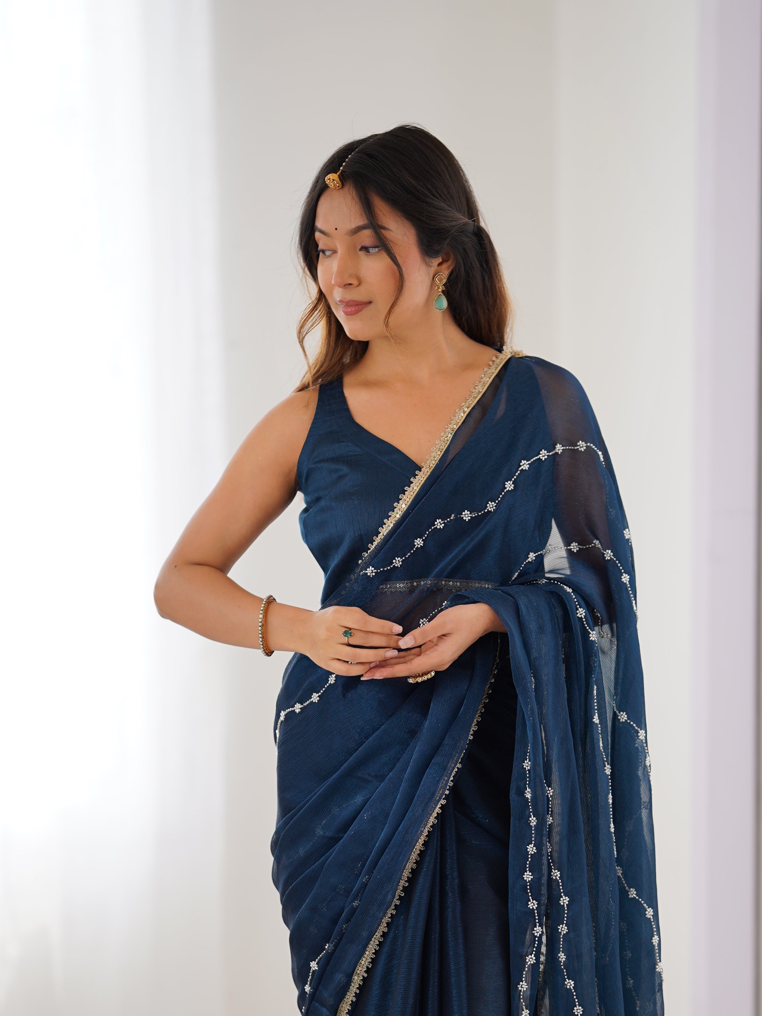 Detailed shot of Petrol Blue Sitara Saree's border and matching unstitched blouse with lace.