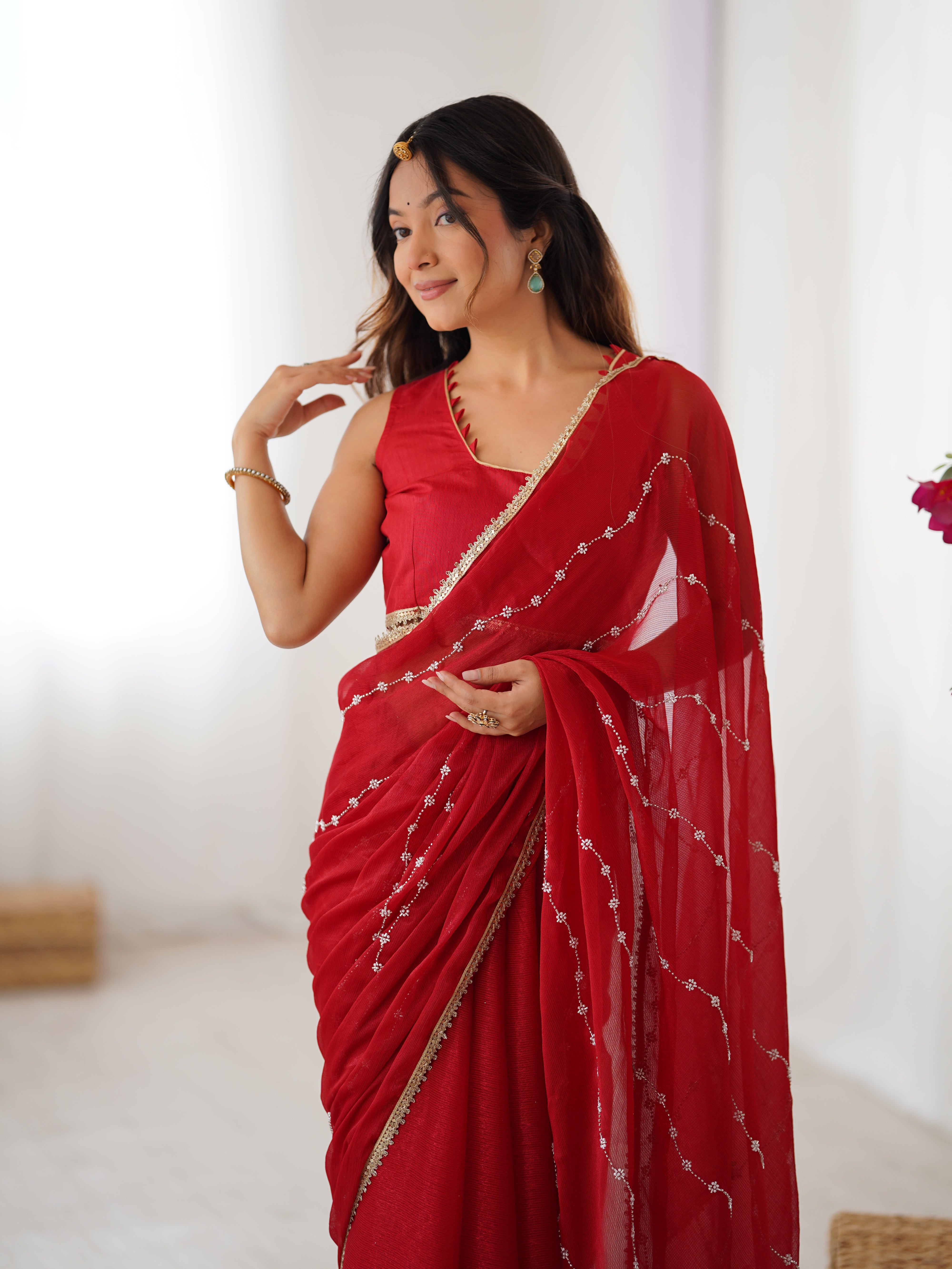 Detailed shot of Red Sitara Saree's border and matching unstitched blouse with lace.