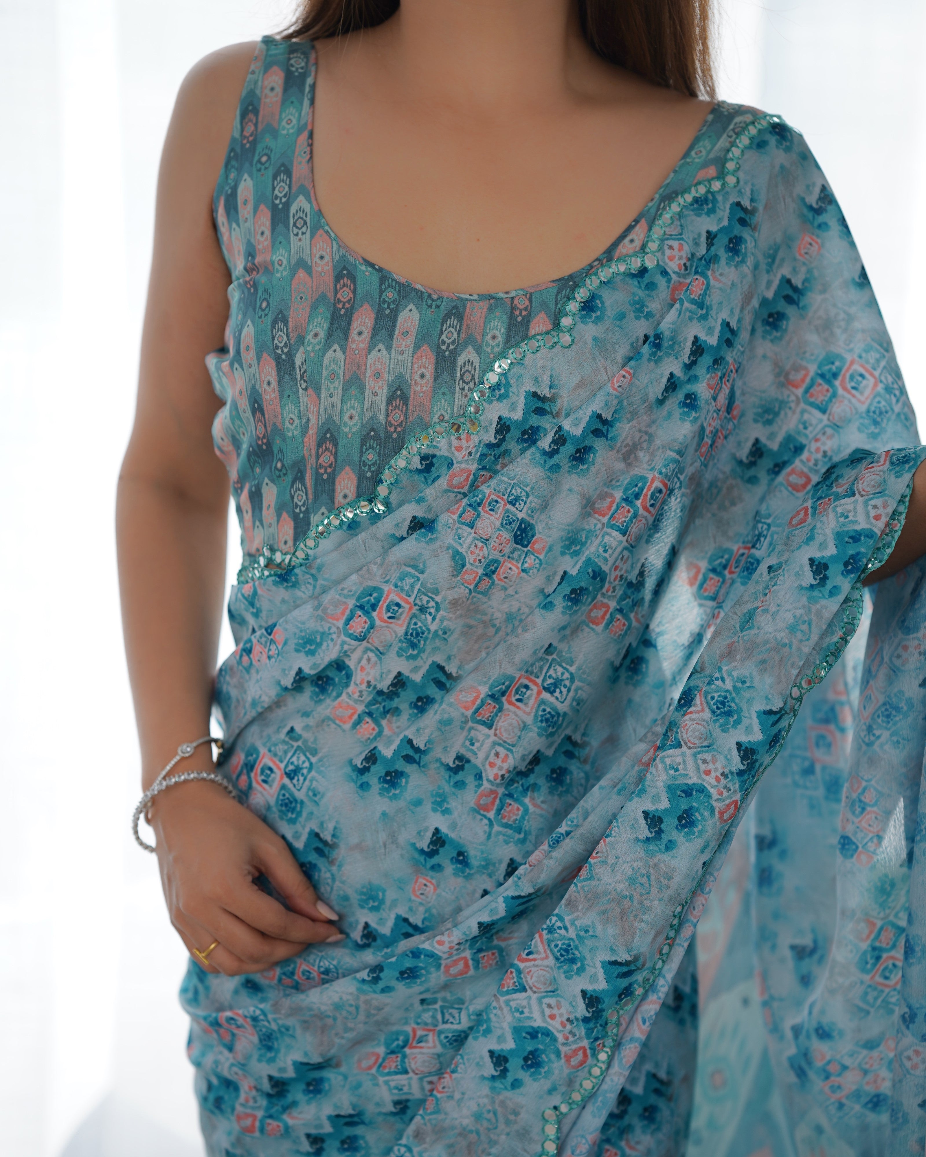 Exclusive heavy blue Chinnon saree with elegant print and Kutchi mirror lace border.