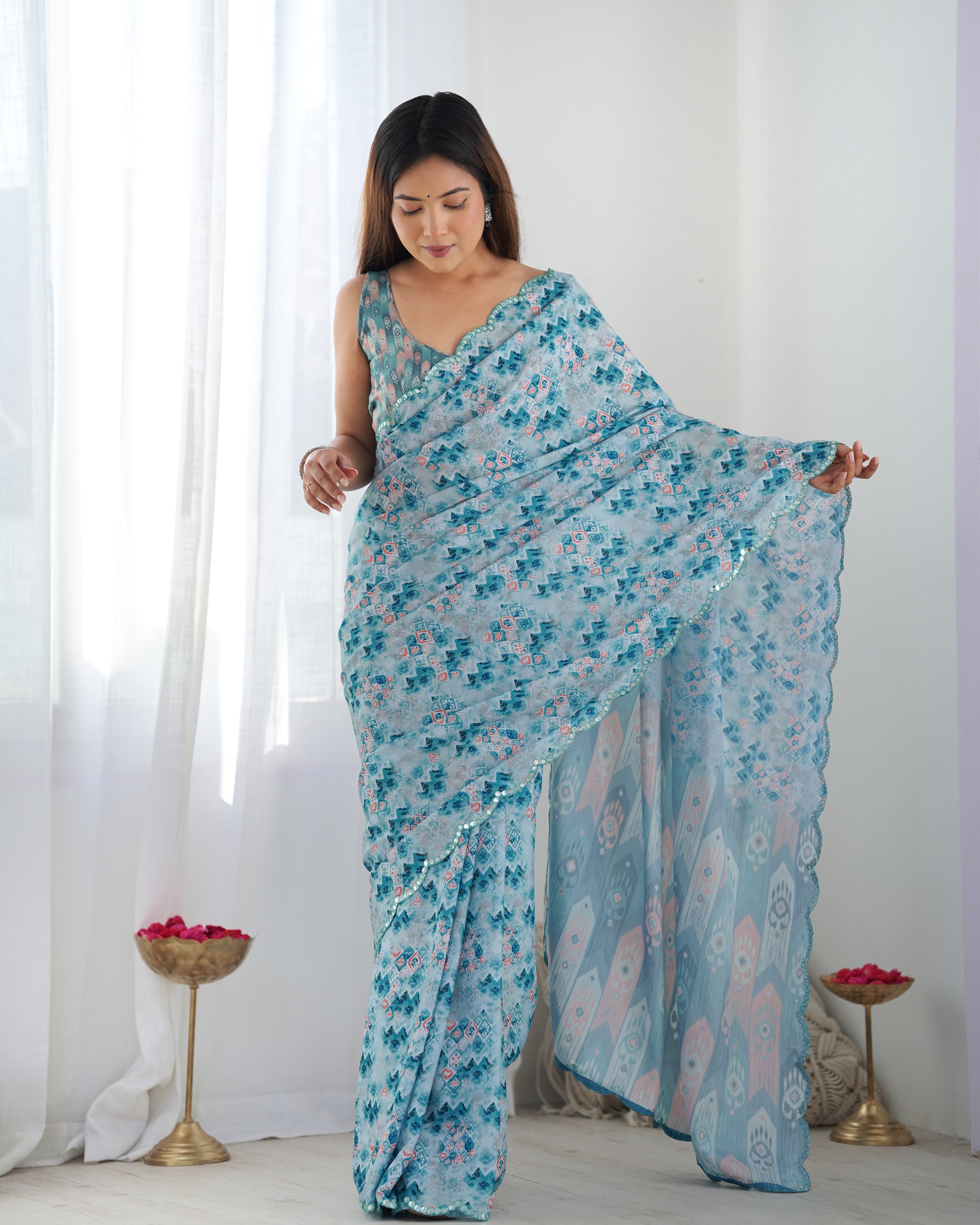 Elegant blue heavy Chinnon saree with floral print and sparkling Kutchi mirror lace border.