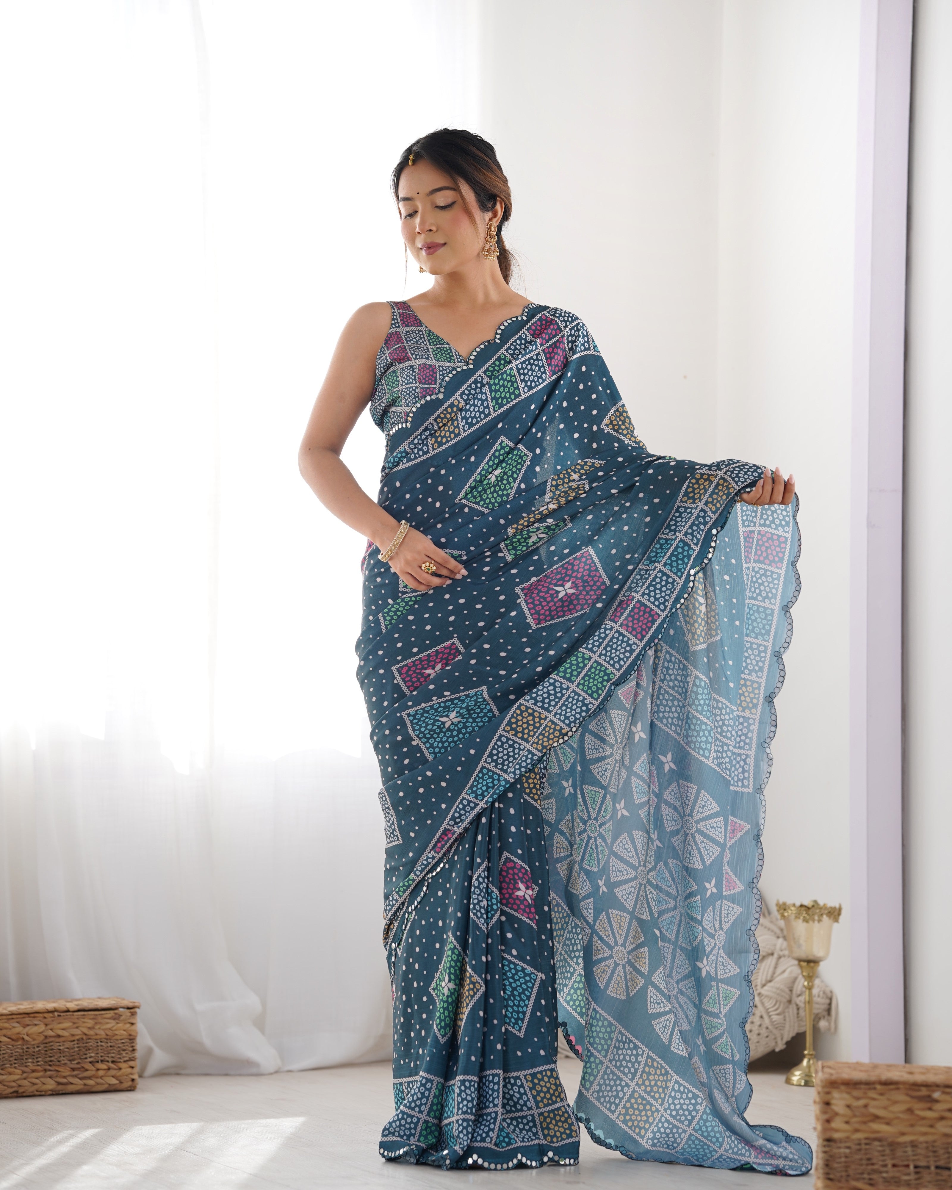 Close-up of elegant teal chinnon saree border showcasing Kutchi mirror work & decorative lace.