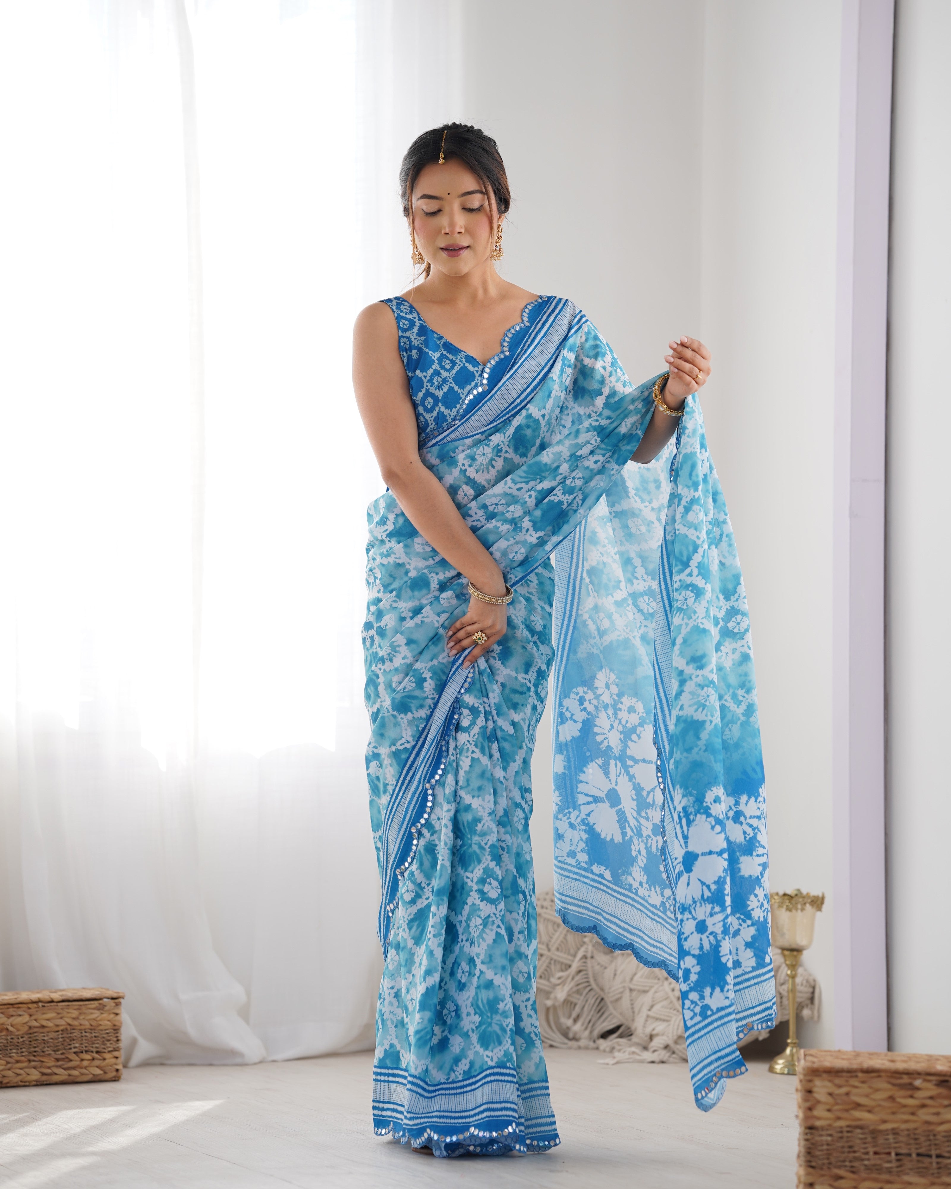 Elegant blue Chinnon saree with Kutchi mirror work lace border.