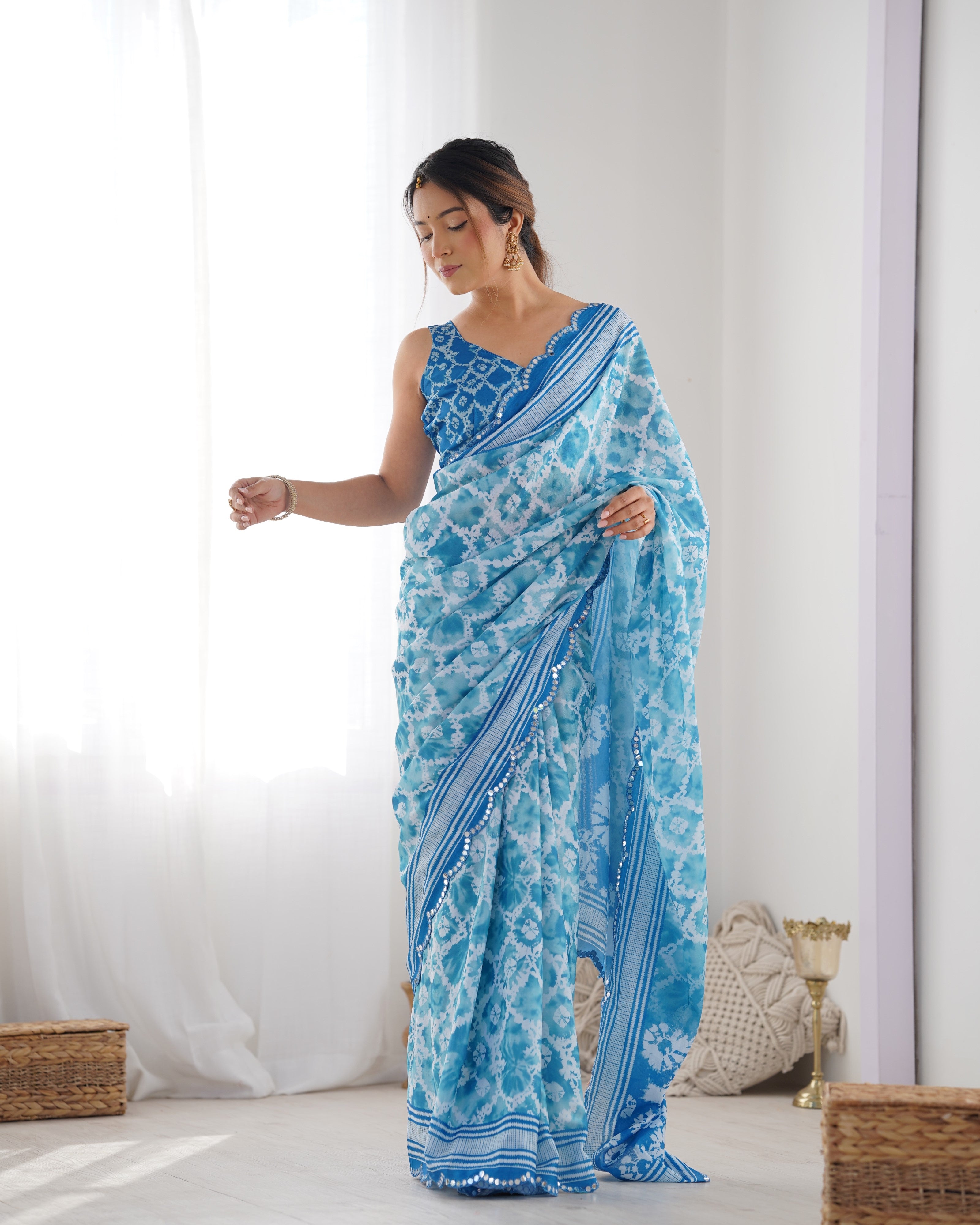 Elegant blue Chinnon saree with Kutchi mirror work lace border and unstitched blouse.
