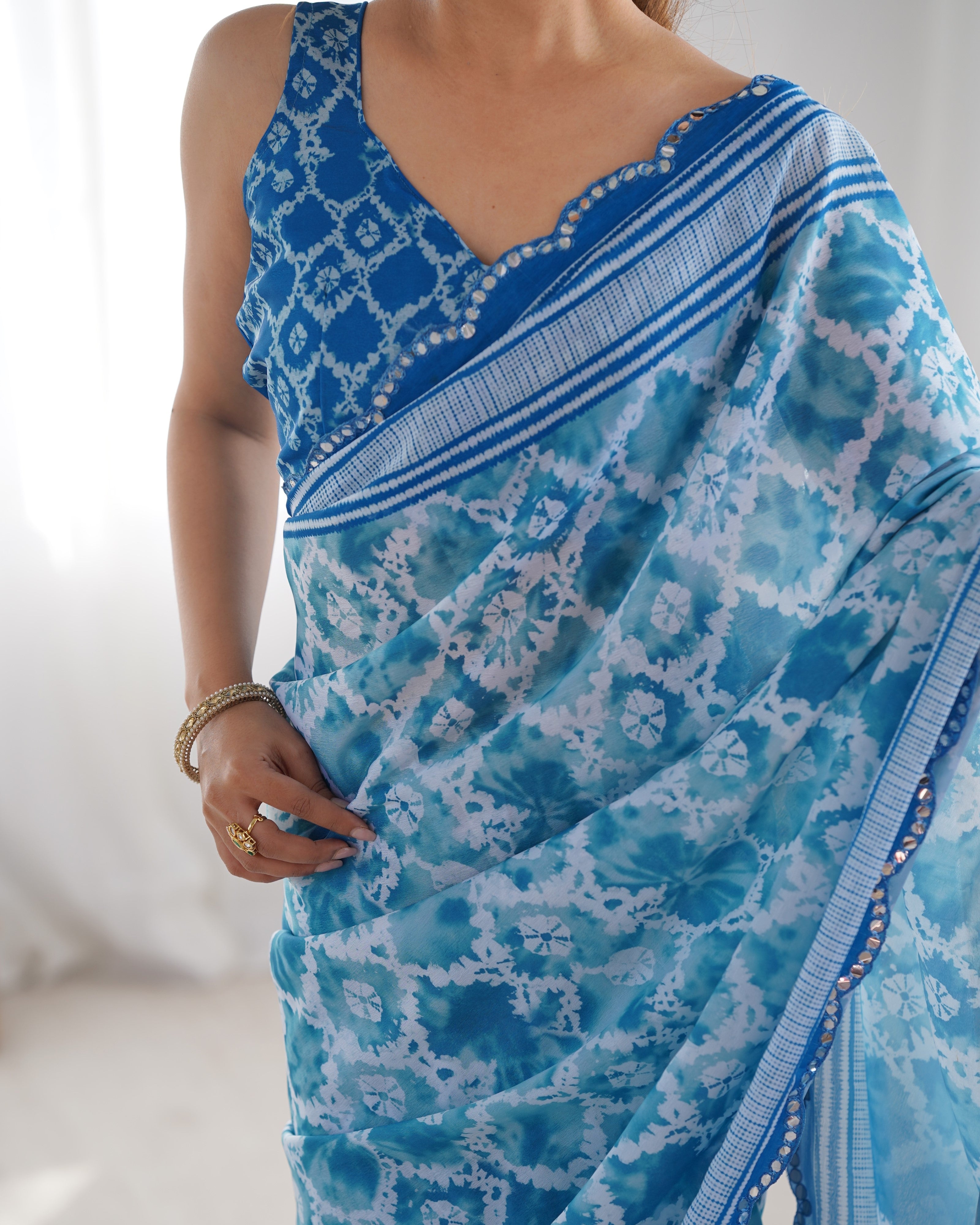 Close-up of elegant blue Chinnon Saree with Kutchi mirror work lace border