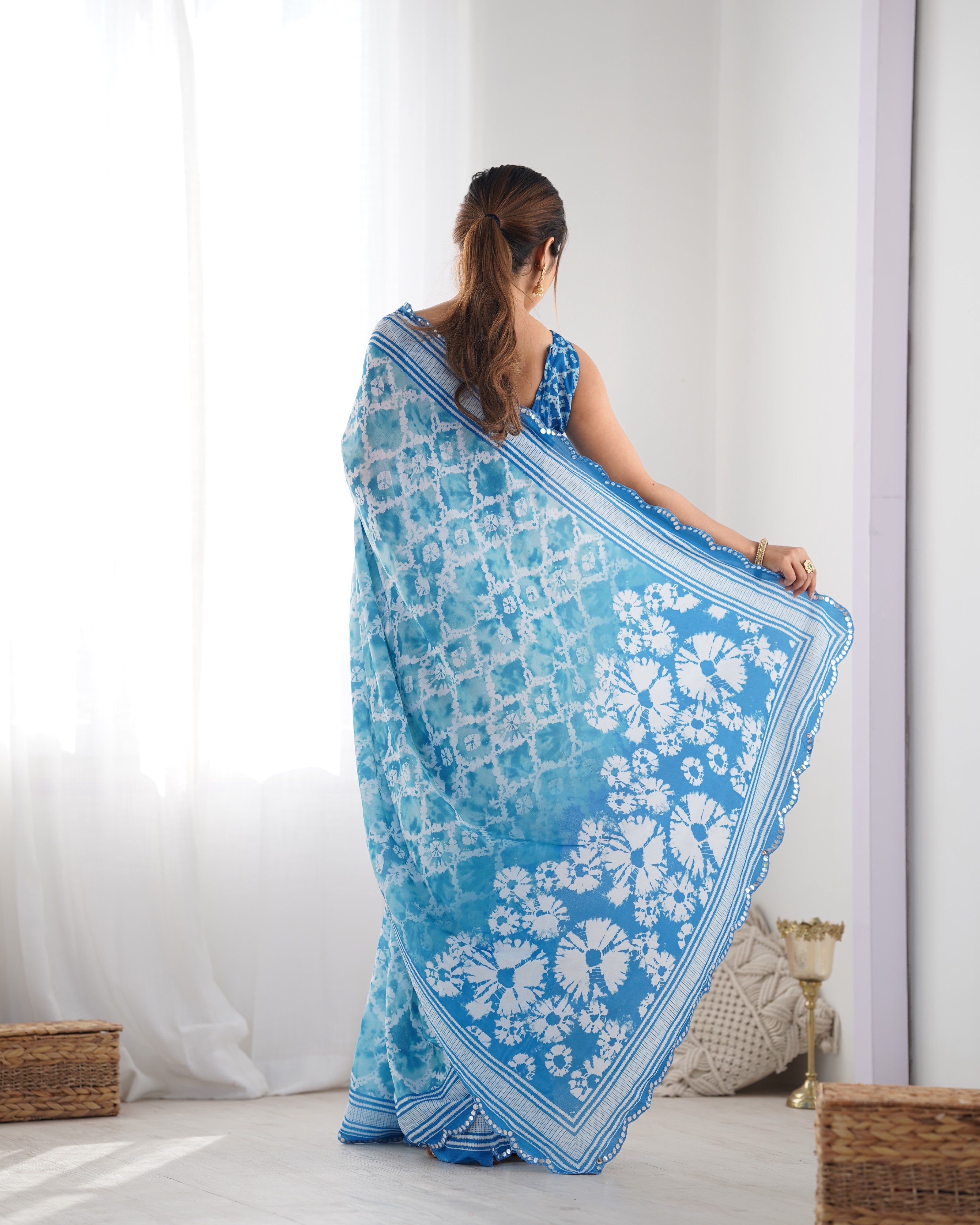 Elegant blue Chinnon saree with intricate Kutchi mirror work lace border